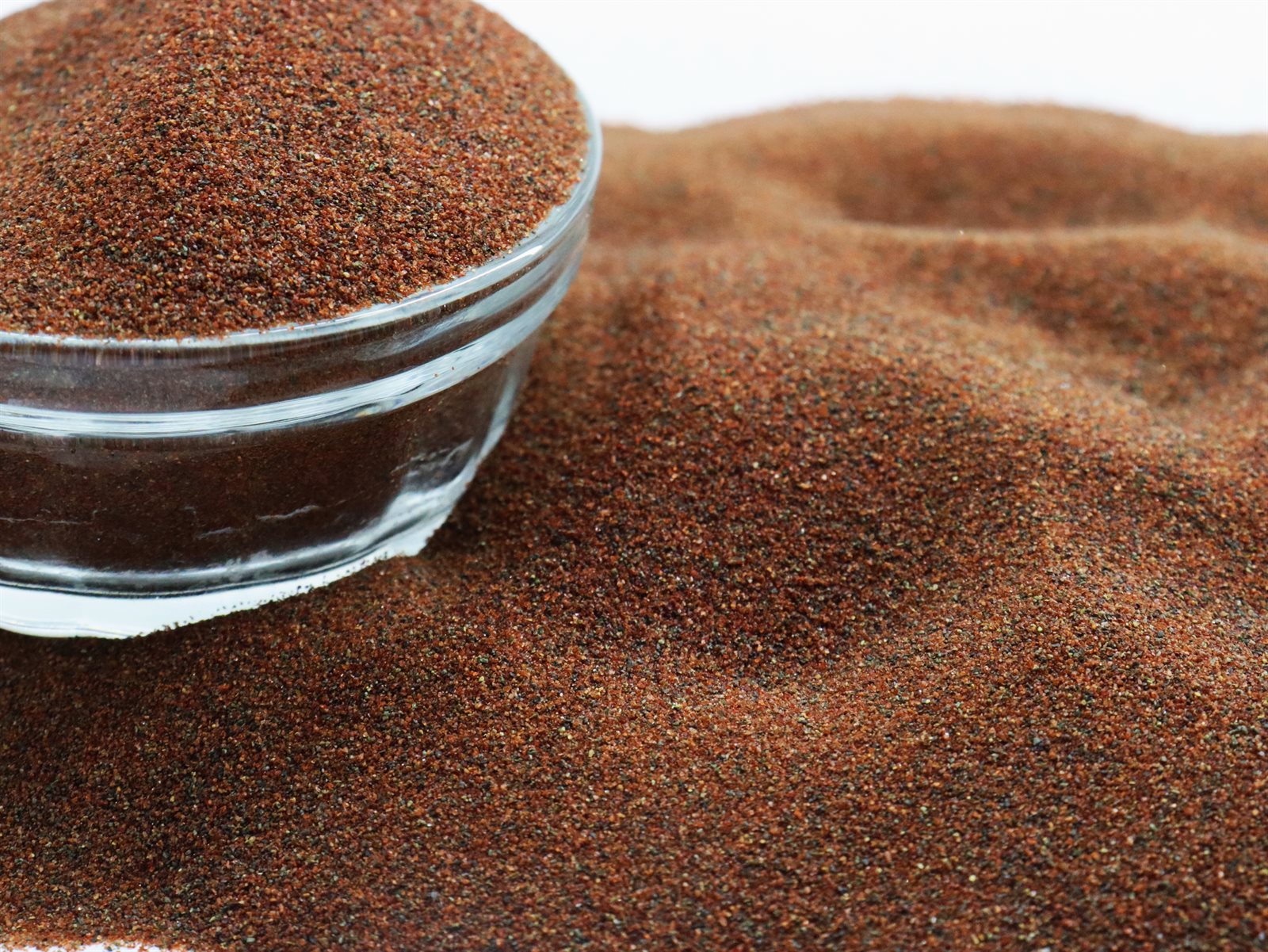 Waterjet garnet abrasive 80A+ 80 mesh grains in a glass bowl, second view